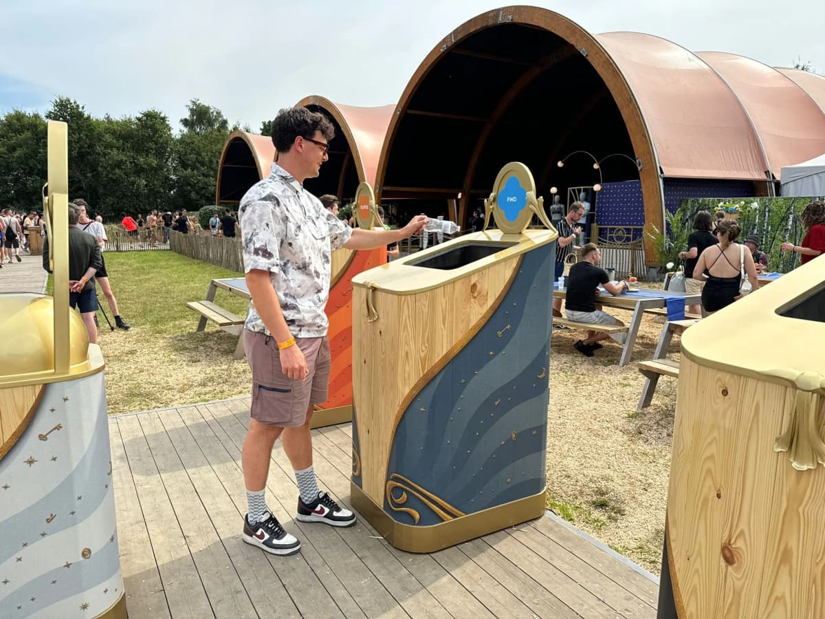 A festival-goer dropping waste into an AI smart bin