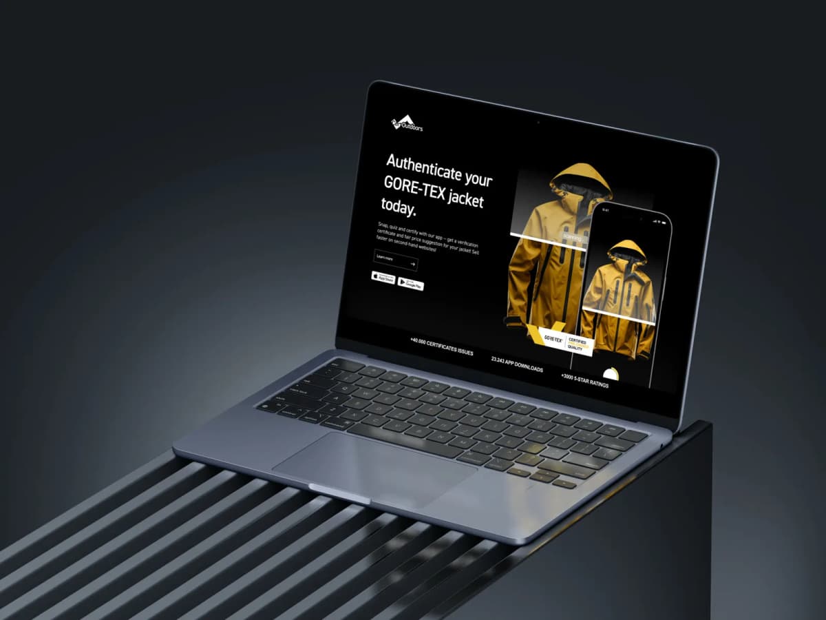 Laptop on a slatted bench showing the landing page: authenticate your GORE-TEX jacket today