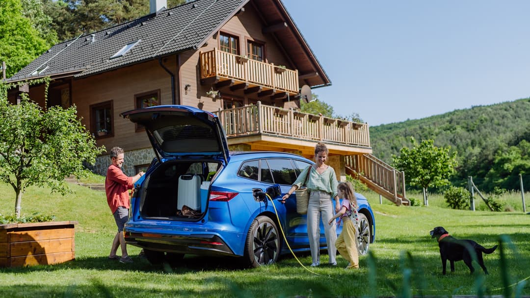 A family charging their electric car outside their home